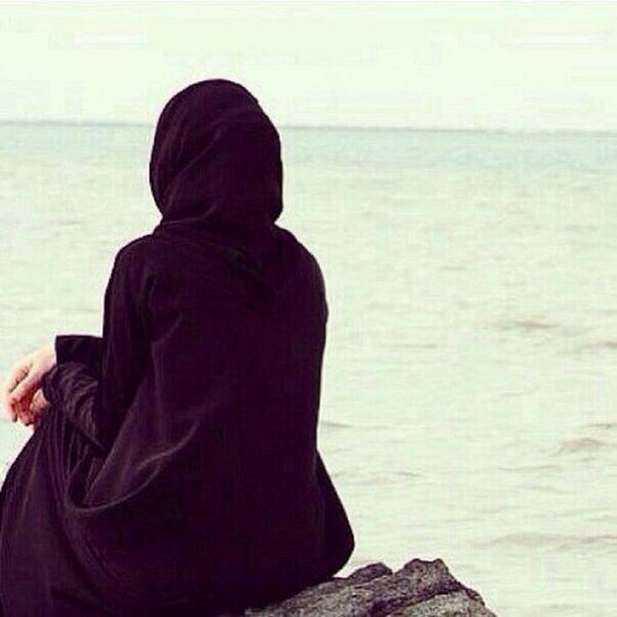 Девушка в черном хиджабе у моря