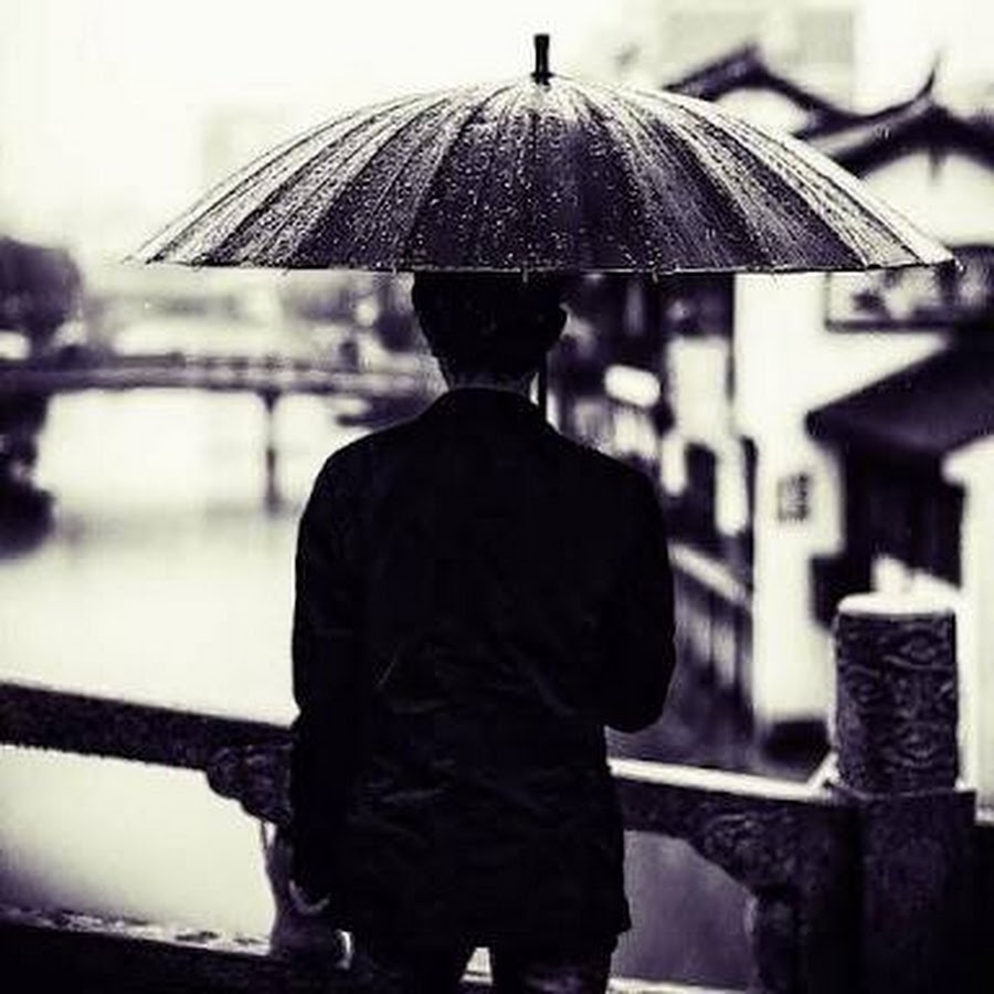 Человек с зонтом под дождем