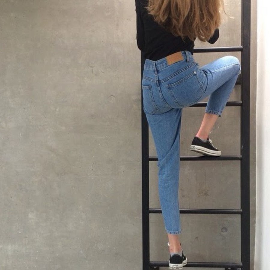 Девушка в джинсах перед зеркалом