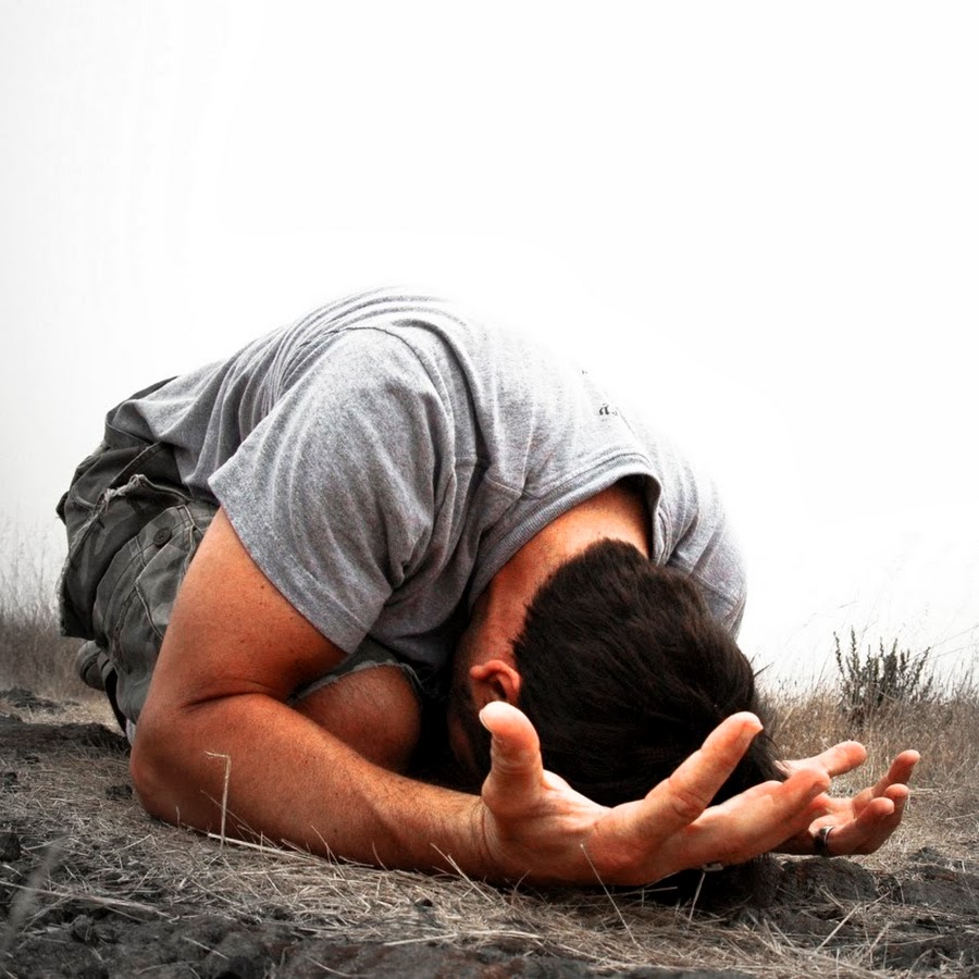 Несчастье показывает. Человек в отчаянии. Мужчина молится на коленях. Парень молится Богу.